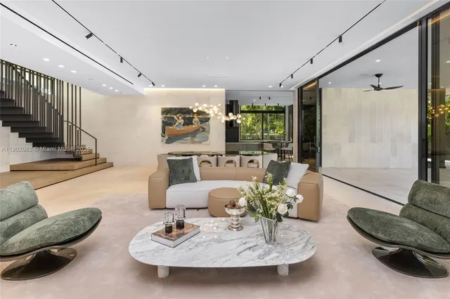 a kitchen with stainless steel appliances granite countertop a table chairs and a refrigerator