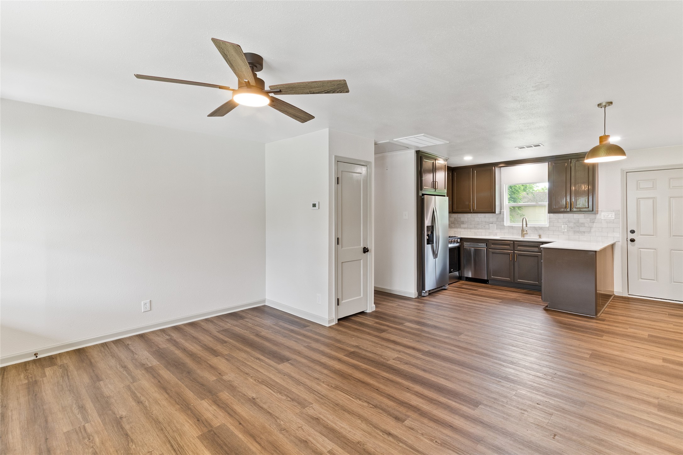 1108 Nottingham Drive Angleton, TX 77515 - Photo 4 of 23 a view of a kitchen with wooden floor and a ceiling fan