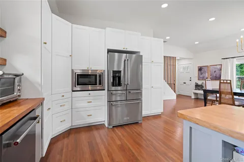 a kitchen with stainless steel appliances granite countertop sink a stove and a wooden floors