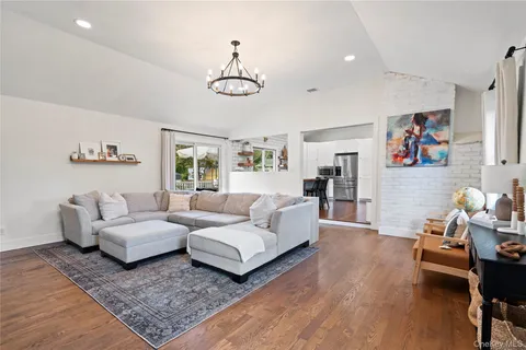 a living room with furniture wooden floor and window