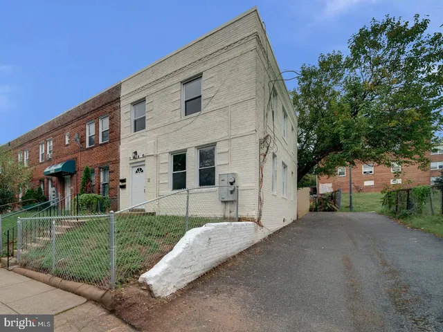 a view of a white house with a yard