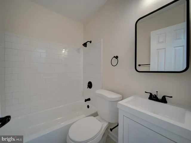 a bath room with a toilet a sink and a bath tub