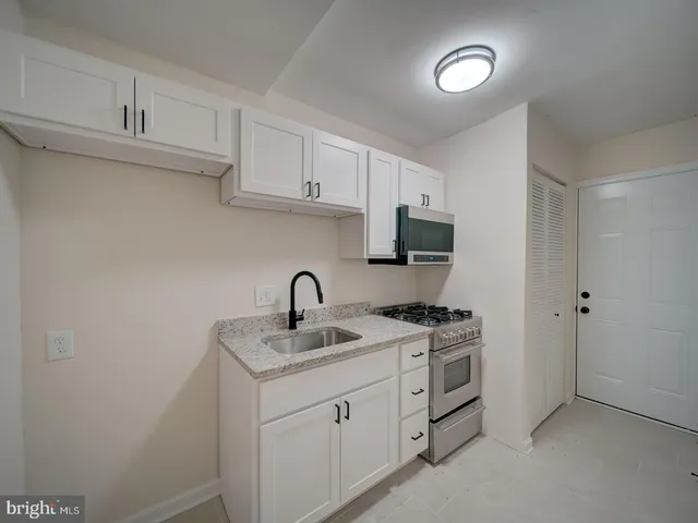 a kitchen with white cabinets appliances and sink