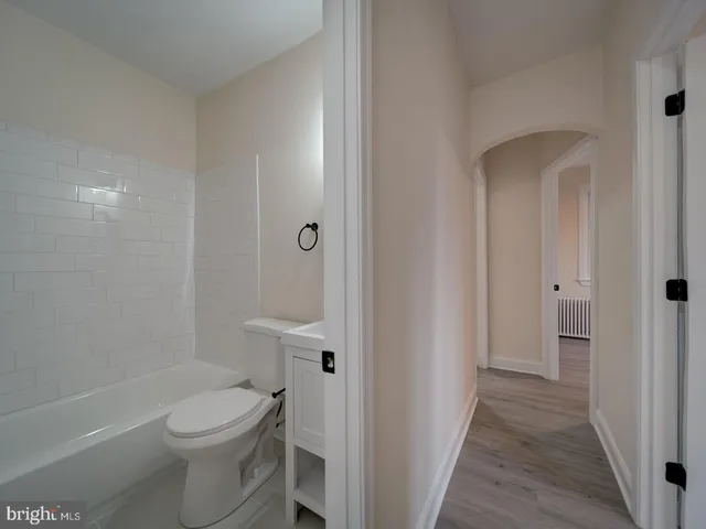 a bathroom with a granite countertop toilet a sink and a bathtub