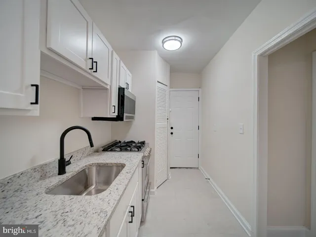 a kitchen with stainless steel appliances granite countertop a sink a stove and a refrigerator