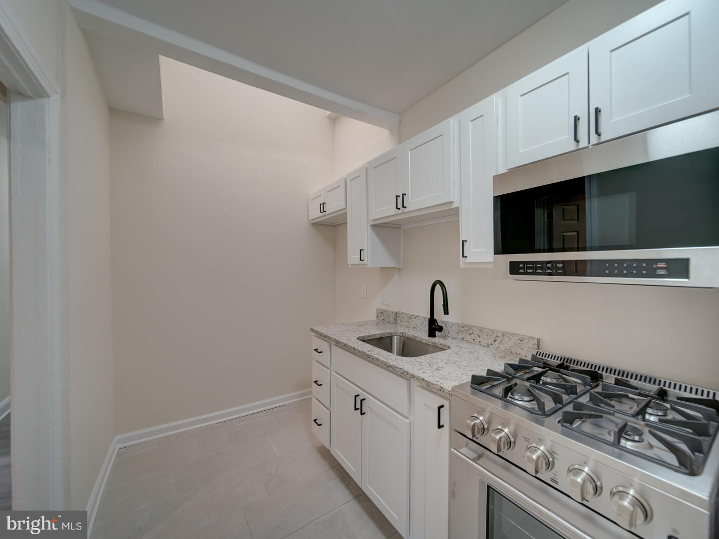1946 I Street Northeast Washington, DC 20002 - Photo 38 of 47 a kitchen with stainless steel appliances a sink dishwasher a stove and a microwave oven on the kitchen countertops