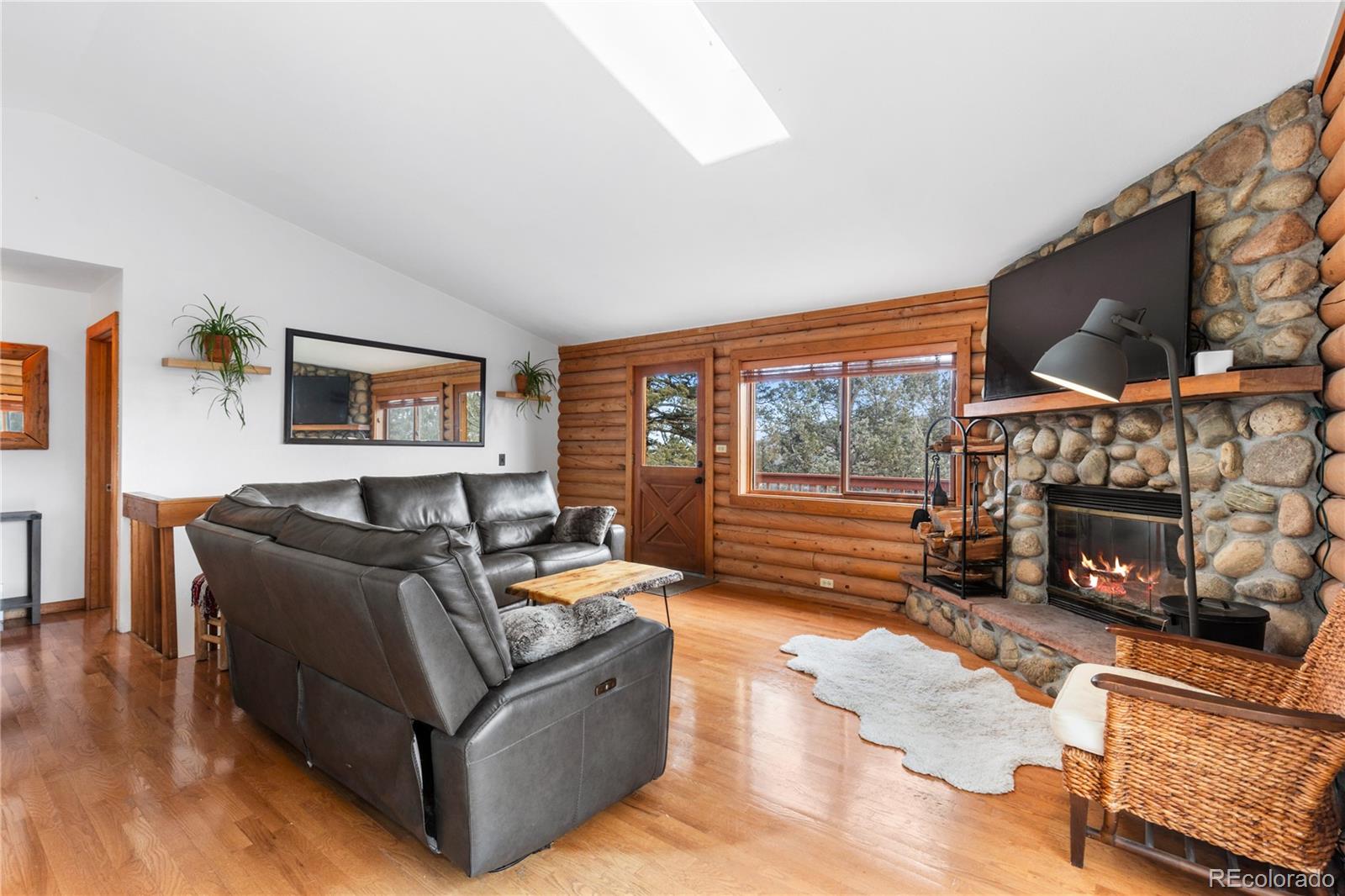 10221 Blue Sky Trail Conifer, CO 80433 - Photo 2 of 37 a living room with furniture a fireplace and a flat screen tv