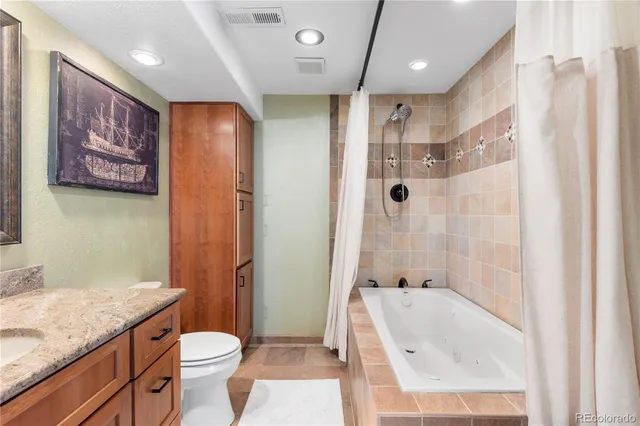a bathroom with a granite countertop sink toilet and shower