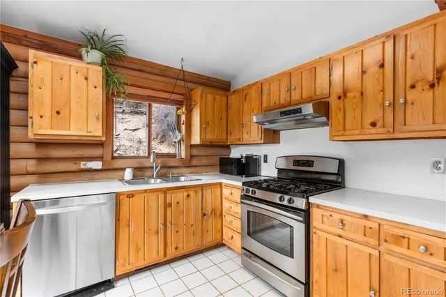 a kitchen with granite countertop a sink stainless steel appliances and cabinets