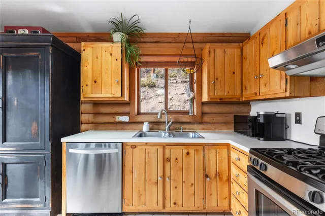 a kitchen with stainless steel appliances granite countertop a sink a stove and a refrigerator