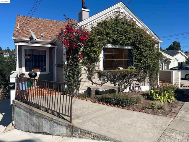 a view of a house with a small yard and potted plants