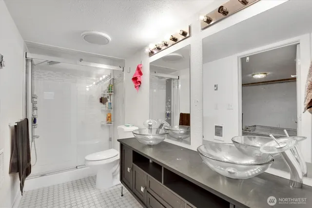 a bathroom with a granite countertop sink a toilet and shower