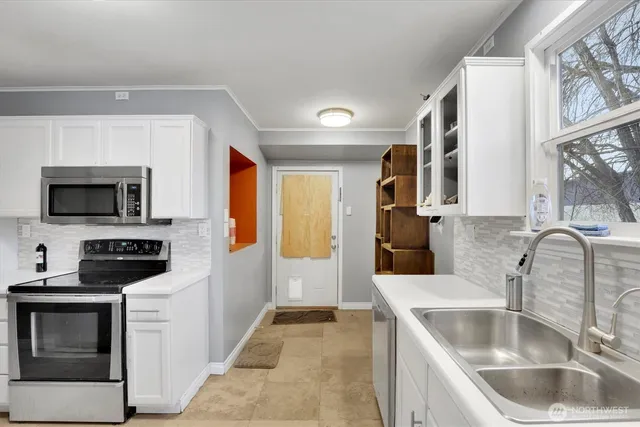 a kitchen with stainless steel appliances granite countertop a sink and a stove top oven