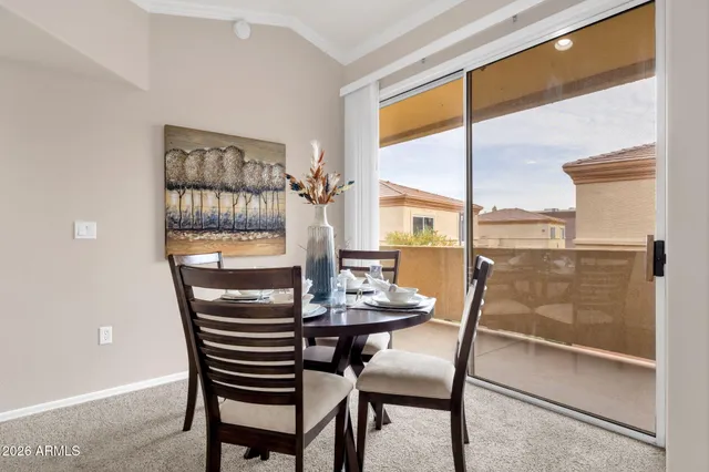 a dining room with furniture and a floor to ceiling window