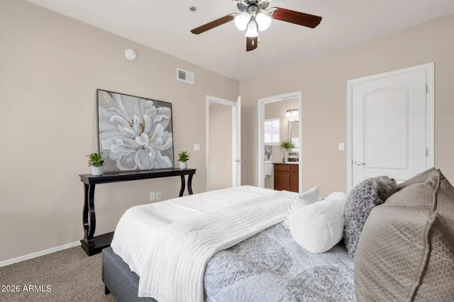 a bedroom with a bed and painting on the wall