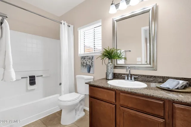 a bathroom with a granite countertop sink toilet a large mirror and shower