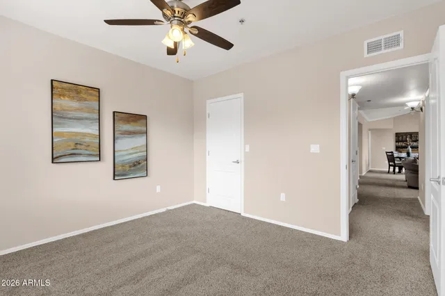 a view of a room with a ceiling fan and windows