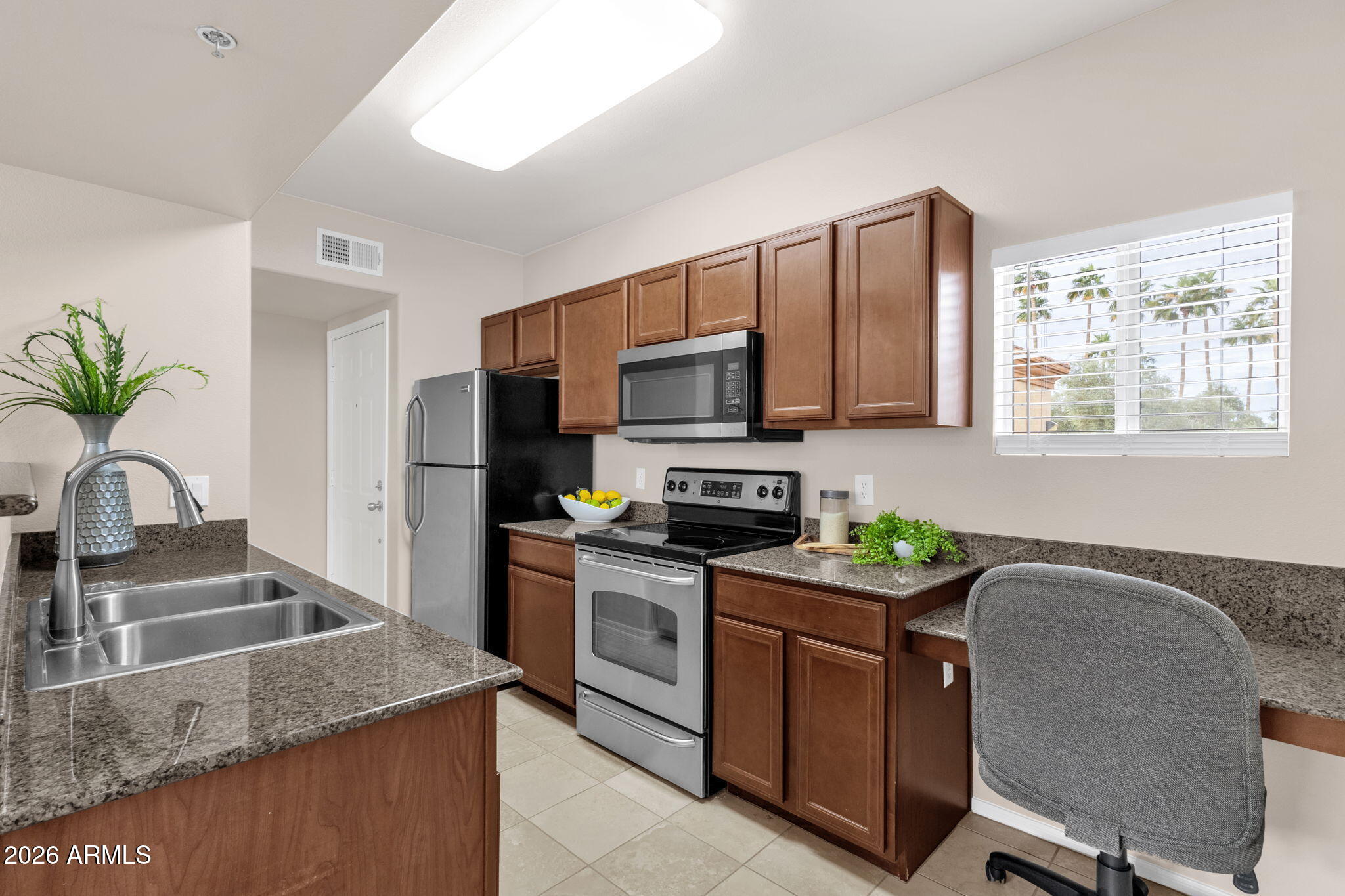 2134 East Broadway Road, Unit 2010 Tempe, AZ 85282 - Photo 7 of 42 a kitchen with kitchen island granite countertop a sink stove and refrigerator