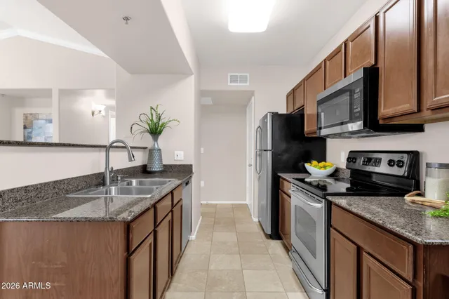 a kitchen with kitchen island granite countertop a sink stove and refrigerator