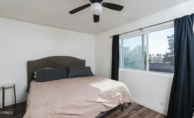 a bedroom with a bed and painting on the wall