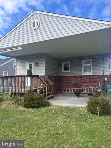 a view of a house with a patio and a yard
