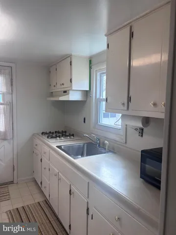 a kitchen that has a lot of cabinets in it and wooden floors