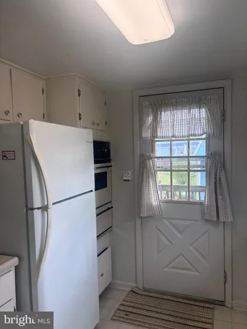 a white refrigerator freezer and a stove sitting inside of a kitchen