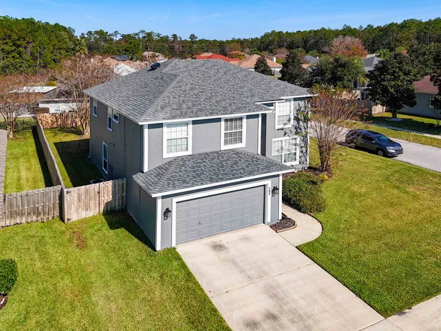 a aerial view of a house with a yard table and chairs