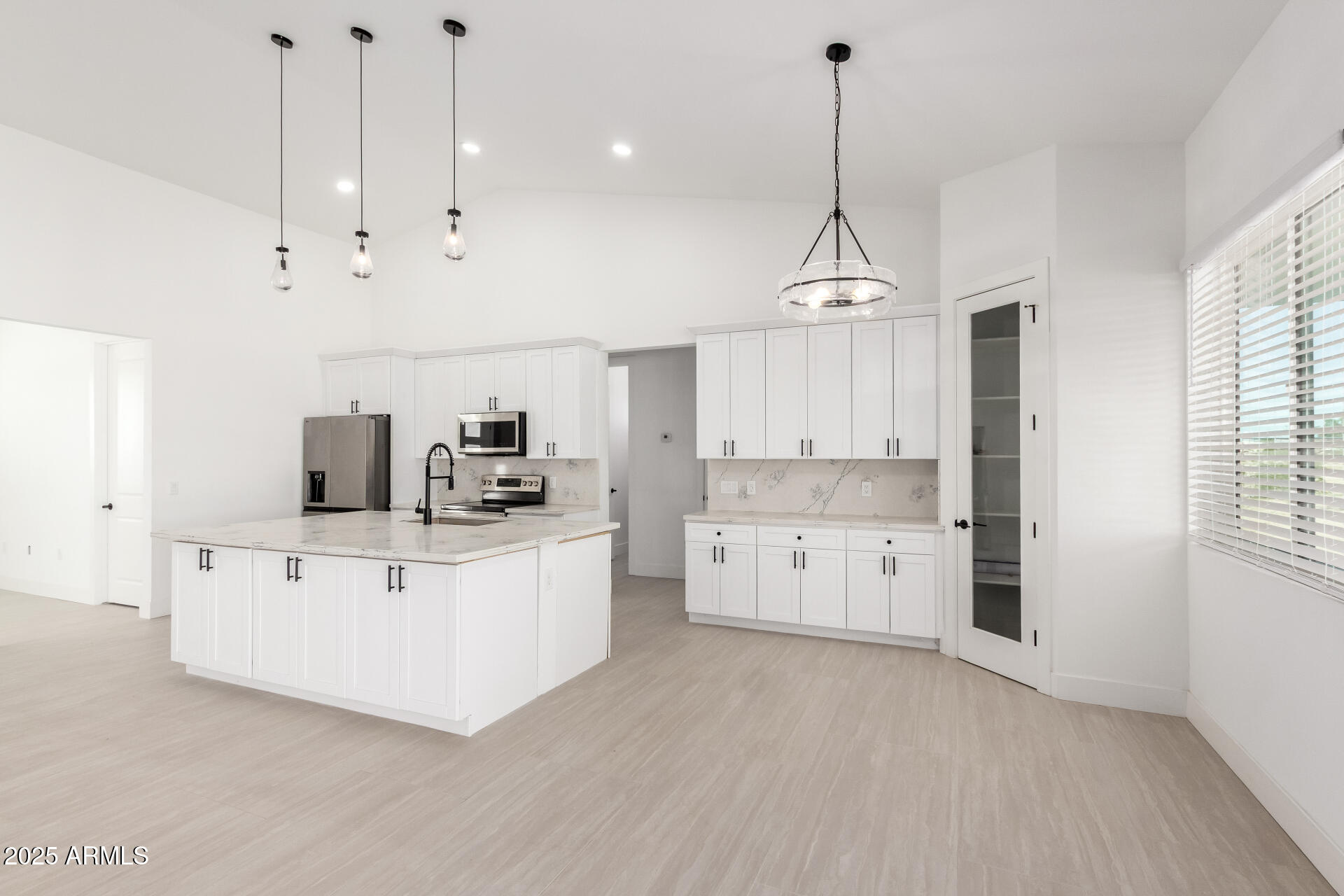 681 North Bruner Road Buckeye, AZ 85396 - Photo 16 of 60 a kitchen with kitchen island white cabinets and white appliances