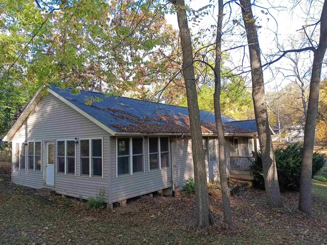 a view of house with a yard and large tree