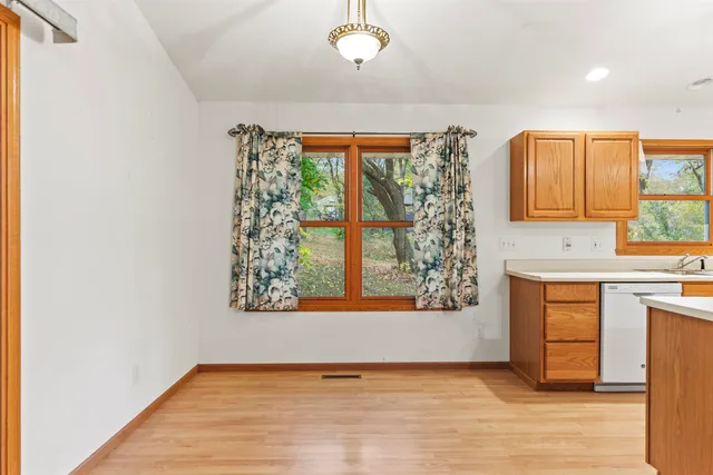 a view of an empty room with a window and bathroom
