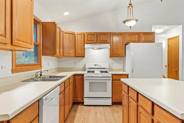 a kitchen with a sink a stove cabinets and a wooden floor