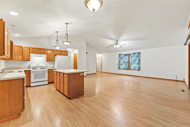 a view of a kitchen with a sink wooden cabinets and a floor to ceiling window