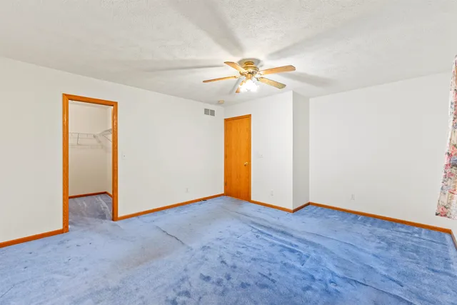 an empty room with a ceiling fan and a window