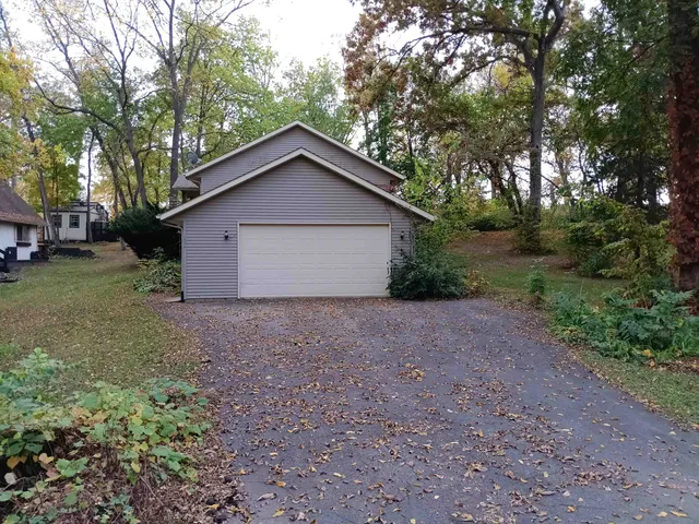 a view of a house with a yard and large trees