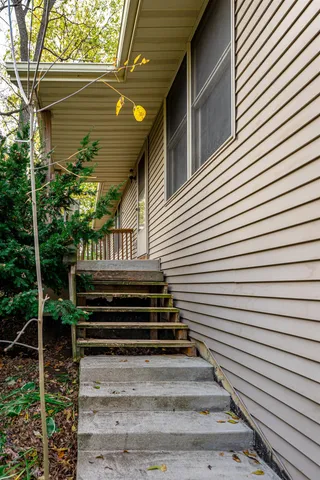 a view of a back side of house with wooden stairs