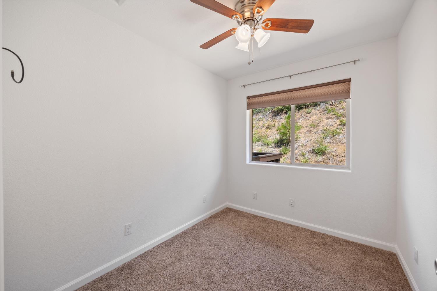 8009 Spring Valley Road Pollock Pines, CA 95726 - Photo 22 of 31 an empty room with a window and a fan