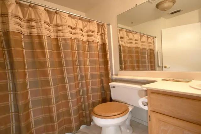 a bathroom with a sink a toilet and a window