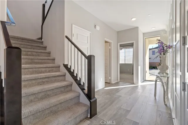 a view of a hallway with wooden floor and staircase