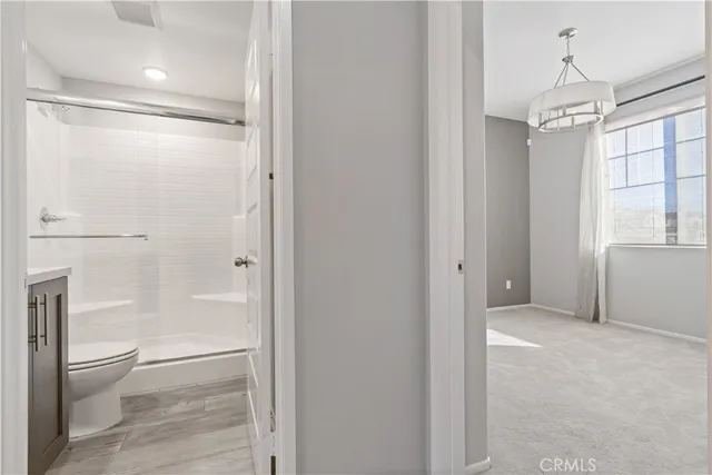 a bathroom with a granite countertop sink a toilet and shower