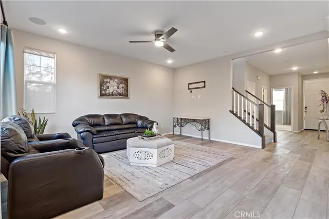 a living room with furniture and a wooden floor