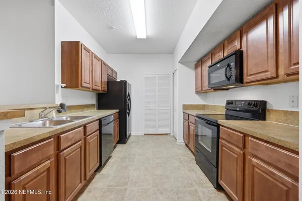 a kitchen with stainless steel appliances granite countertop a sink stove and cabinets
