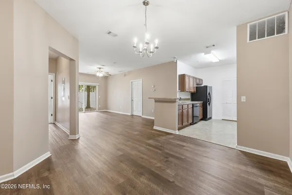 a view of a kitchen with wooden floor and a refrigerator
