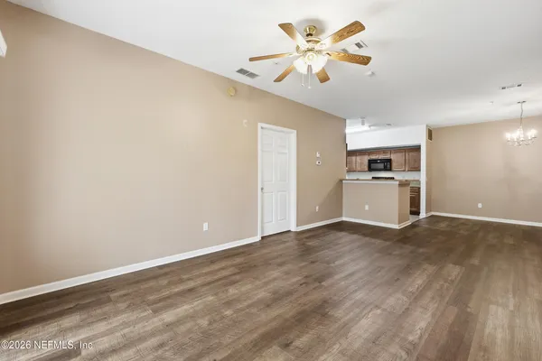 wooden floor in an empty room with a kitchen