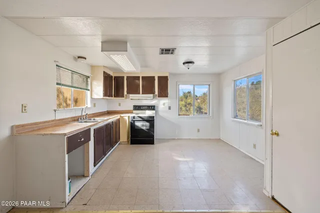 a large kitchen with stainless steel appliances kitchen island a large counter space a sink and a window