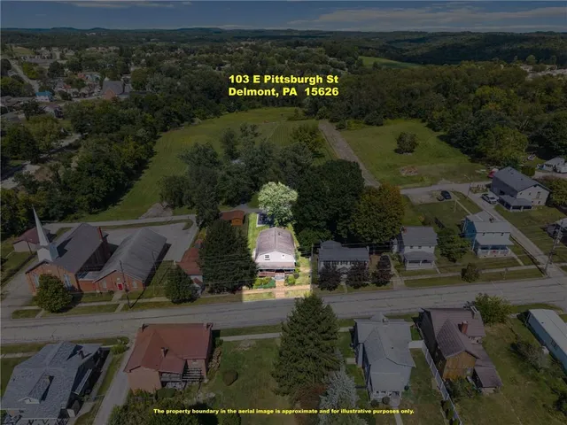 an aerial view of a house with a yard and table and chairs