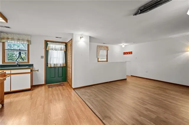 a view of a kitchen with wooden floor and a window