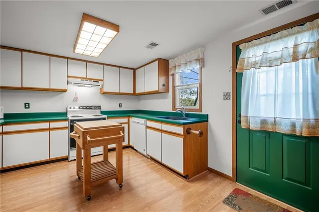 a kitchen with stainless steel appliances granite countertop a stove a sink and a refrigerator