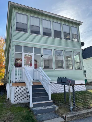 a front view of a house with stairs and a yard