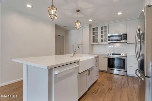 a kitchen with kitchen island a sink stainless steel appliances and cabinets